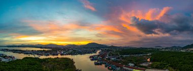 Kıyı kenti limanına yansıyan renkli günbatımı gökyüzü