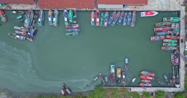 Sakin yeşil su limanına yanaşan renkli tekneler