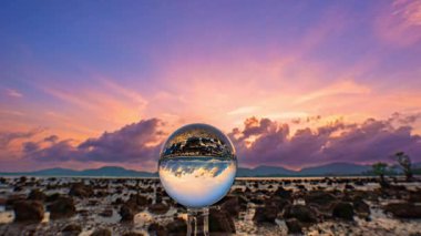 Renkli günbatımı gökyüzü dışarıdaki cam küreye yansıyor.