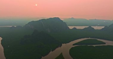 Sarmal nehir ve dağların üzerinde puslu gün doğumu