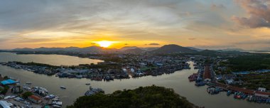 Durgun denizi yansıtan canlı sarı, pembe ve mor gün batımının nefes kesici görüntüsü. Bu sakin sahne Phuket balıkçılık limanında doğanın renklerinin güzelliğini yakalar. renkli bulut manzarası arkaplanı