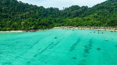 Berrak turkuaz suları, yemyeşil bitki örtüsü ve mercan resifleriyle çevrili tenha Surin adalarının nefes kesici bir görüntüsü. El değmemiş beyaz kum ve canlı okyanus renkleri
