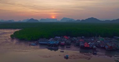 Alacakaranlıktaki Bang Phat balıkçı köyündeki gökyüzü manzarası. Mangrov ormanlarıyla çevrili küçük, ıssız bir adada yaşayan bir balıkçı köyündeki alacakaranlık gökyüzünün yansıması..
