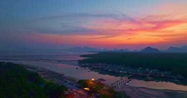 Alacakaranlıktaki Bang Phat balıkçı köyündeki gökyüzü manzarası. Mangrov ormanlarıyla çevrili küçük, ıssız bir adada yaşayan bir balıkçı köyündeki alacakaranlık gökyüzünün yansıması..