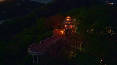 Alacakaranlıktaki Khao Rang manzarası. Gün batımında yemyeşil dağların arasına yerleşmiş bir kasabanın manzarası. Dusk 'taki Phuket kasabasının yamacında bir Pavilion yapısı var.