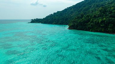 Berrak turkuaz suları, yemyeşil bitki örtüsü ve mercan resifleriyle çevrili tenha Surin adalarının nefes kesici bir görüntüsü. El değmemiş beyaz kum ve canlı okyanus renkleri