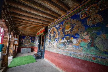 Ladakh India, 25 Haziran 2025: Yükselen dağların ve yuvarlanan bulutların geniş panoramasına karşı, kırmızı boyalı manastır nefes kesici bir dönüm noktası olarak ortaya çıktı. Renkli duvarlar ve altın süslemeler.