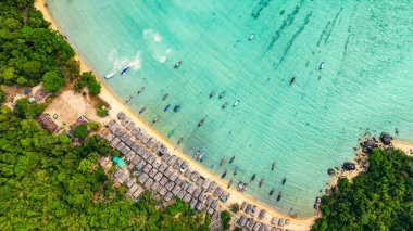 Morgan Köyü 'nün Surin Adası' ndaki doğal güzelliklere gizlenmiş havadan görüntüsü. Kıyı şeridi boyunca yemyeşil ormanlarla çevrili küçük kulübeler. Balıkçı tekneleri turkuaz sularda demirli..    