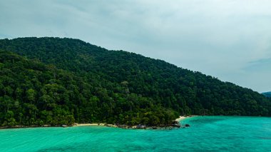 Berrak turkuaz suları, yemyeşil bitki örtüsü ve mercan resifleriyle çevrili tenha Surin adalarının nefes kesici bir görüntüsü. El değmemiş beyaz kum ve canlı okyanus renkleri