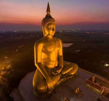Muang Ang Tayland 'da, Tayland' ın büyük altın Buda simgesinin arkasında gün batımı..