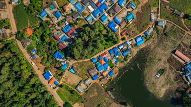 Tayland Burma sınırındaki sakin Lakeside Köyü. Sakin ve yansıtıcı bir göl kenarına kurulmuş sakin bir dağ köyü olan Baan Arunothai 'yi nefes kesen bir hava manzarası yakalıyor. Etrafı yemyeşil tepelerle çevrili.