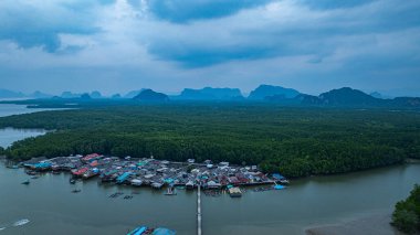 Küçük bir köprünün havadan görünüşü, mangrov ormanlarıyla çevrili küçük bir adada yaşayan bir balıkçı köyüne bağlanır. Önünde denize açılan bir kanal var, çeşitli deniz yaşamı açısından zengin..