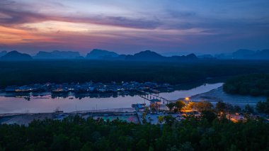 Alacakaranlıktaki Bang Phat balıkçı köyündeki gökyüzü manzarası. Mangrov ormanlarıyla çevrili küçük, ıssız bir adada yaşayan bir balıkçı köyündeki alacakaranlık gökyüzünün yansıması..