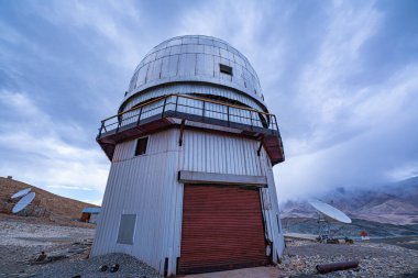 Ladakh Hanle 'deki Hint Astronomik Gözlemevi, beyaz bulutların sürüklendiği engin mavi gökyüzünün altında yer alır. Yerleşimi ve yalnızlığı derin uzay gözlemi için mükemmel bir nokta yaratır..
