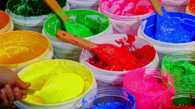 Plastisol mürekkebinden kepçe yeşili. Kovalar dolusu renkli boya. Sanatı, tasarımı ve hayal gücünü ön plana çıkaran kalın, damlayan renkler içeren çoklu boya kovalarını kapat.