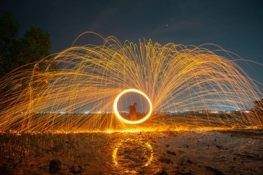 Çelik yünden kıvılcımlar çıkan kıvılcımların yansıması deniz alacakaranlığında soyut bir hız hareketi..