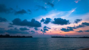 Sakin okyanus rengarenk günbatımı gökyüzünü yansıtıyor