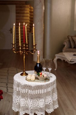 Mumlarla dolu eski bir şamdan ve şekerli bardaklarla dolu bir şişe.