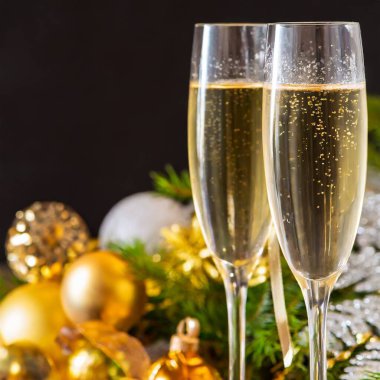 Yeni yıl arifesinde iki bardak şampanya Noel 'i kutluyor ve kış tatilini kutluyoruz. Yüksek kalite fotoğraf