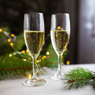 Yeni yıl arifesinde iki bardak şampanya Noel 'i kutluyor ve kış tatilini kutluyoruz. Yüksek kalite fotoğraf