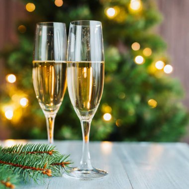 Yeni yıl arifesinde iki bardak şampanya Noel 'i kutluyor ve kış tatilini kutluyoruz. Yüksek kalite fotoğraf