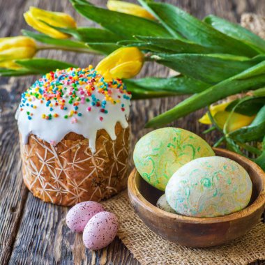 Paskalya yumurtası ve pasta gri masa arkasında. Bahar tatili için mutlu paskalya arkaplanı