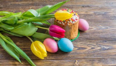 Paskalya yumurtası ve pasta gri masa arkasında. Bahar tatili için mutlu paskalya arkaplanı