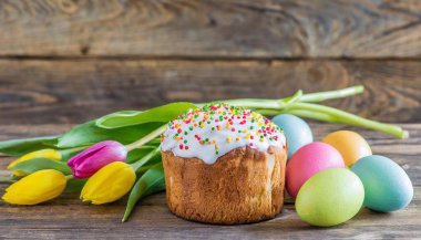 Paskalya yumurtası ve pasta gri masa arkasında. Bahar tatili için mutlu paskalya arkaplanı
