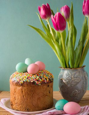 Paskalya yumurtası ve pasta gri masa arkasında. Bahar tatili için mutlu paskalya arkaplanı