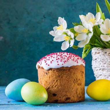 Paskalya yumurtası ve pasta gri masa arkasında. Bahar tatili için mutlu paskalya arkaplanı