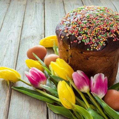 Paskalya yumurtası ve pasta gri masa arkasında. Bahar tatili için mutlu paskalya arkaplanı