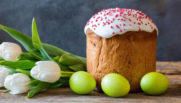 Paskalya yumurtası ve pasta gri masa arkasında. Bahar tatili için mutlu paskalya arkaplanı