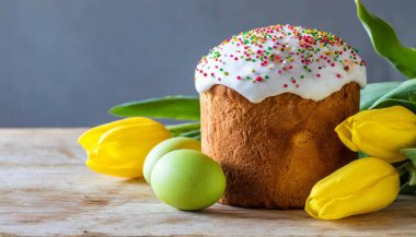 Paskalya yumurtası ve pasta gri masa arkasında. Bahar tatili için mutlu paskalya arkaplanı
