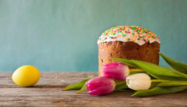 Paskalya yumurtası ve pasta gri masa arkasında. Bahar tatili için mutlu paskalya arkaplanı