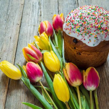 Paskalya yumurtası ve pasta gri masa arkasında. Bahar tatili için mutlu paskalya arkaplanı