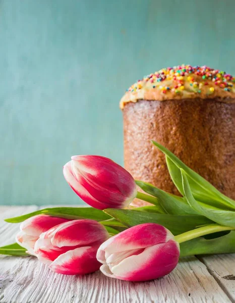 Paskalya yumurtası ve pasta gri masa arkasında. Bahar tatili için mutlu paskalya arkaplanı