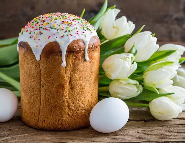 Paskalya yumurtası ve pasta gri masa arkasında. Bahar tatili için mutlu paskalya arkaplanı