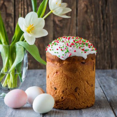 Paskalya yumurtası ve pasta gri masa arkasında. Bahar tatili için mutlu paskalya arkaplanı