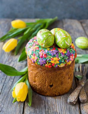 Paskalya yumurtası ve pasta gri masa arkasında. Bahar tatili için mutlu paskalya arkaplanı