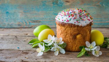 Paskalya yumurtası ve pasta gri masa arkasında. Bahar tatili için mutlu paskalya arkaplanı