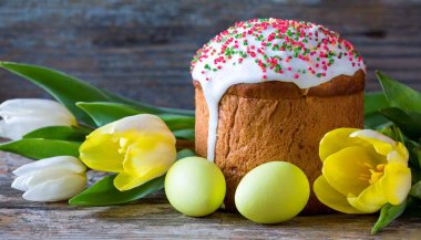 Paskalya yumurtası ve pasta gri masa arkasında. Bahar tatili için mutlu paskalya arkaplanı