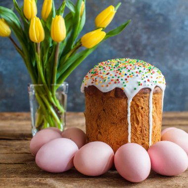 Paskalya yumurtası ve pasta gri masa arkasında. Bahar tatili için mutlu paskalya arkaplanı