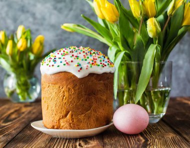 Paskalya yumurtası ve pasta gri masa arkasında. Bahar tatili için mutlu paskalya arkaplanı