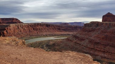 Bu çarpıcı fotoğraf Gooseneck Overlook 'un Moab, Utah' taki dramatik güzelliğini yansıtıyor. Colorado Nehri, kızıl kaya kanyonunu keserek doğa severler ve maceraperestler için görülmesi gereken nefes kesici bir manzara yaratır.