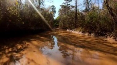 Arkansas Ozarks 'ta büyük bir çamur birikintisinin içinden geçerken off-road araçlarının kaputuna otur..