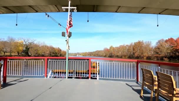 オハイオ川のサンタウィーラーパドルボートパドルホイールと愛国的な旗が橋の下を通過するときの魅惑的な動きを体験してください — ストック動画
