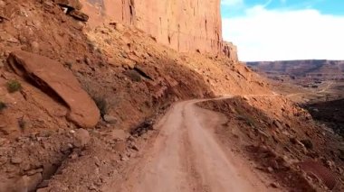 Shafer Trail 'den, farklı renk ve şekillerden oluşan devasa uçurumlara, açık gökyüzü ile çelişiyor. Ufuk, Moab Utah 'ın doğal bir başyapıtı olan ibiklerle ve pürüzlü özelliklerle dolu..