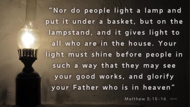 聖書の詩で燃えているランプ マタイ5 16は 光のビーコンとして信者を描写し 暗闇に覆われた世界で神の光を輝かせ すべての人に彼の栄光を示しています — ストック動画