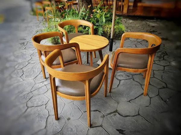 Ahşap masa ve sandalyeler bahçede