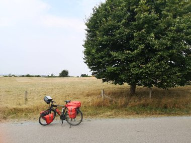 Bir tarlanın ve bir ağacın önünde uzun bir bisiklet.